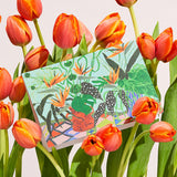 an everyday greetings card with pot plants and flowers on it sitting in a bunch of tulips