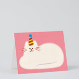 pink greetings card showing an illustration of a fluffy white cat lying down wearing a party hat
