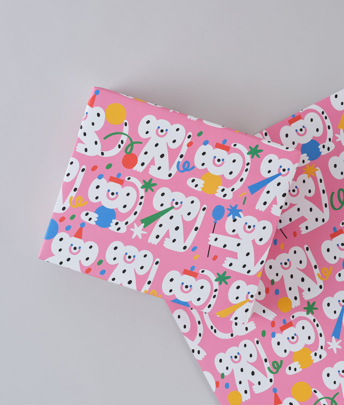 polka dot monkeys celebrating with hats and streamers cover this pink celebration birthday wrapping paper