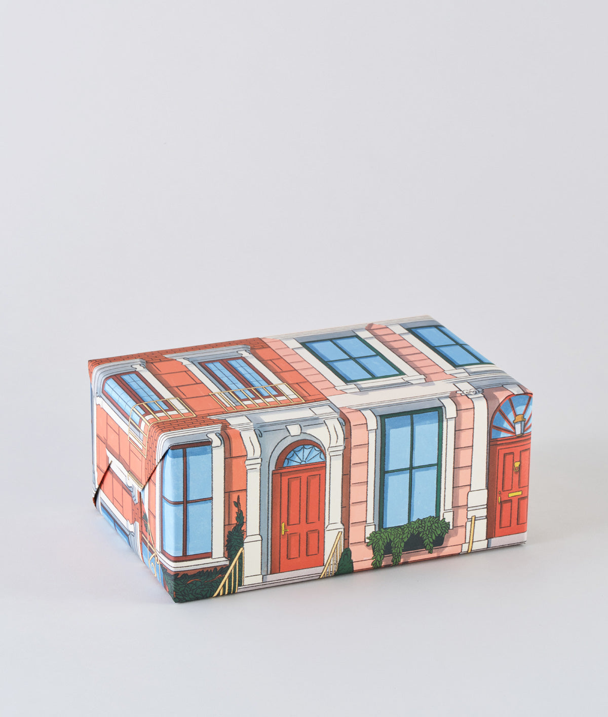 wrapped present in architecture building print wrapping paper, doors and windows with walk up steps.