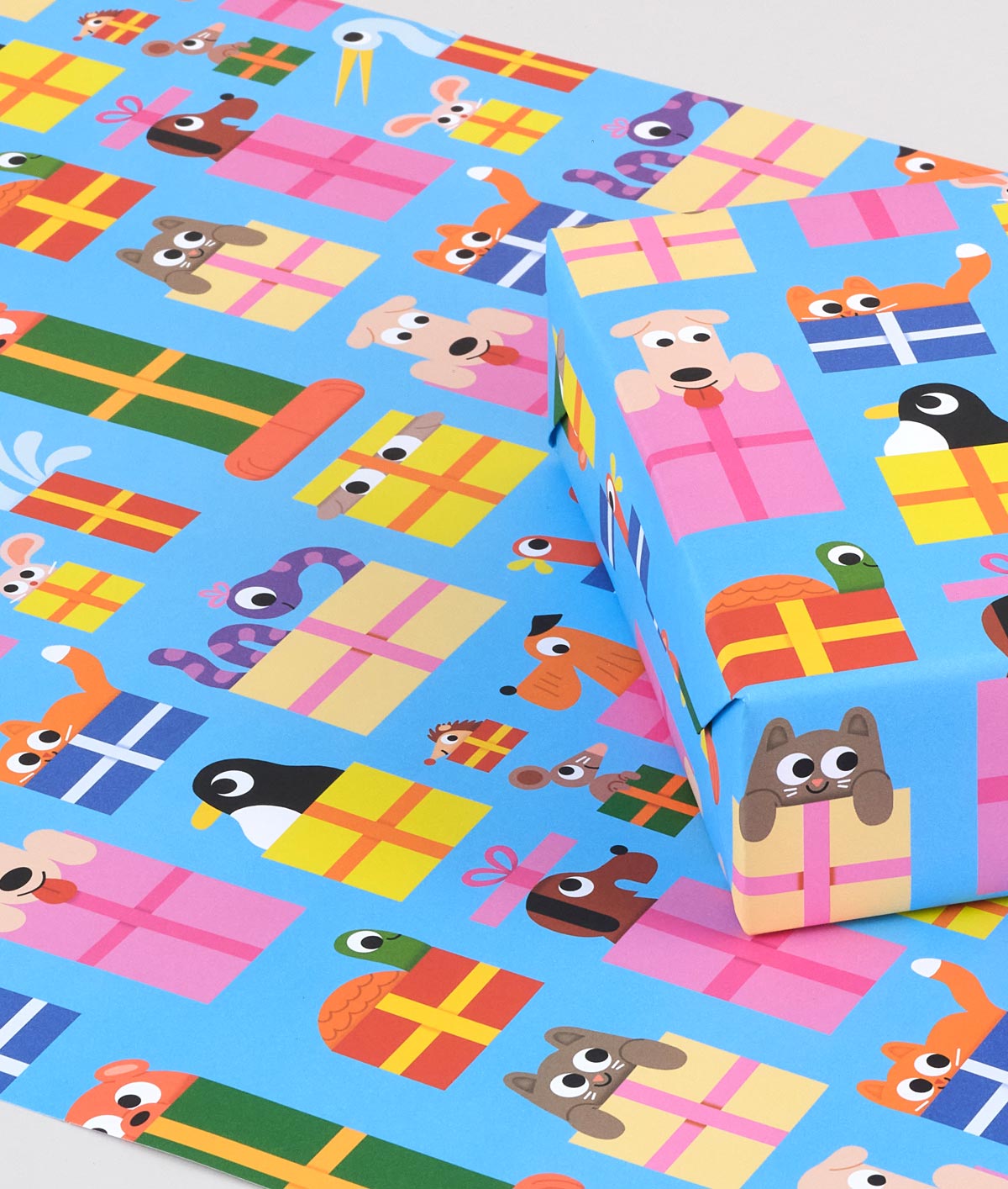 Image is a present wrapped in wrapping paper covered infun cartoon animals peeping out of presents on a blue background