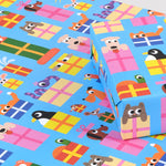 Image is a present wrapped in wrapping paper covered infun cartoon animals peeping out of presents on a blue background