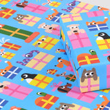 Image is a present wrapped in wrapping paper covered infun cartoon animals peeping out of presents on a blue background