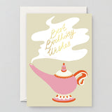 a pink genies lamp with a cloud of smoke coming out it, in which it says best birthday wishes in gold