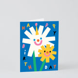 a happy smiley floral kids birthday card that says happy birthday in different colours on a blue background