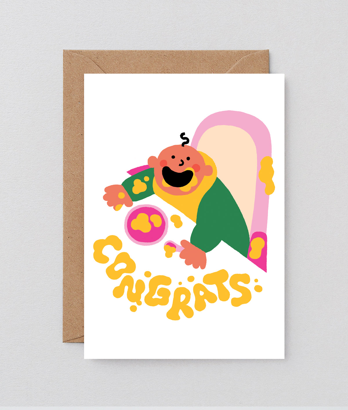 new baby card with baby covered in food and congrats spelled out in splat marks on the table