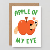 apple with a happy little worm and a small heart on a white back ground, text reads apple of my eye