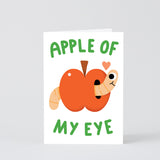 apple with a happy little worm and a small heart on a white back ground, text reads apple of my eye