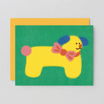Dog birthday card with yellow dog wearing a bowtie on a green background