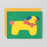 Dog birthday card with yellow dog wearing a bowtie on a green background