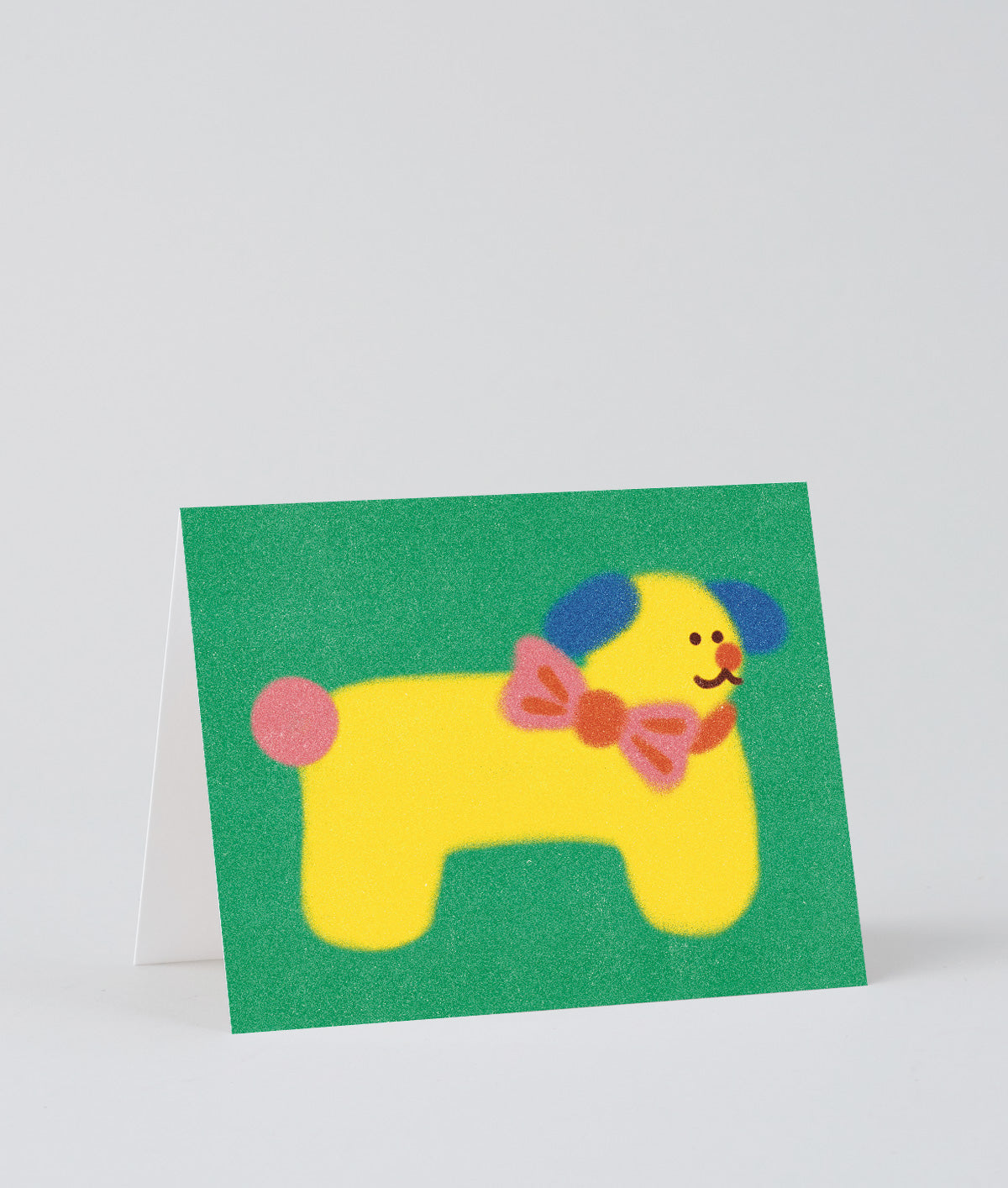 Dog birthday card with yellow dog wearing a bowtie on a green background