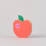 apple with worm die cut out card against a grey background