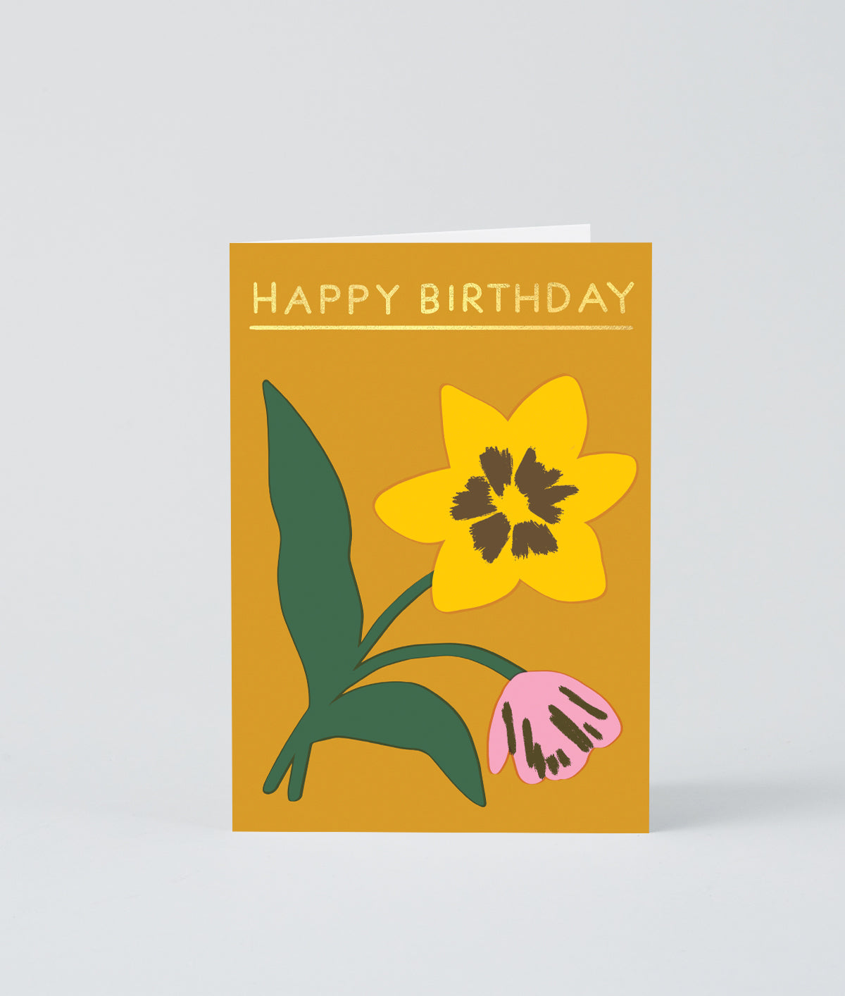 a flower birthday card on a mustard background with happy birthday written in gold